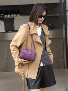Detail view of the purple leather crossbody bag, featuring stylish front zipper and hardware.