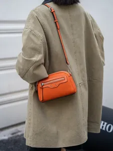 Orange leather crossbody bag for women, stylish small square shoulder bag for commute.
