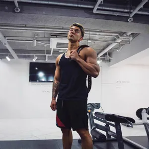 Detailansicht Fitness Tanktop für Herren im modernen Trainingsstudio, atmungsaktiv.