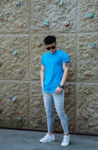Detailed view of the bright blue mens short sleeve t shirt worn by a model outdoor.