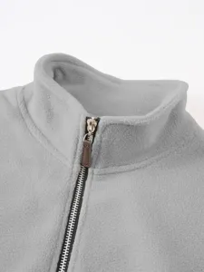 Gedetailleerde close-up van grijs fleece sweatshirt met opstaande kraag en halve rits.