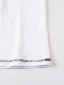 Close up detail view of white men t-shirt hem with dark contrast overlock stitch craftsmanship.