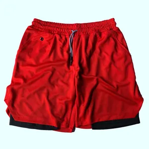 Gros plan detail du short de sport rouge pour homme avec couche interieure noire et cordon.