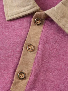 Close-up detail of men's polo shirt collar, placket and buttons, knit fabric texture.