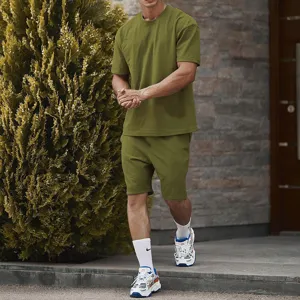 Olive green mens casual sportswear detail, short sleeve t-shirt and shorts set background scene.