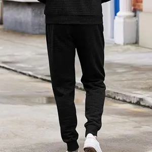 Men black waffle knit casual pants detail view, showing textured fabric and tapered fit.