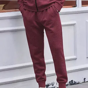 Men casual waffle textured sweatpants detail, winter maroon drawstring tapered pants close-up view
