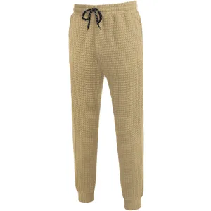 Men's casual pants detailed view, khaki waffle knit fabric, comfortable drawstring waist and cuffed ankles.