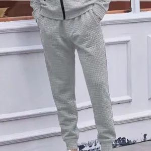 Detail view of mens grey waffle knit casual trousers, comfortable drawstring joggers for daily wear.