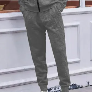 Grey textured casual trousers detail showing waffle knit pattern and elastic cuff.