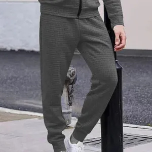 Close-up detail of mens casual gray waffle knit grid trousers tapered joggers autumn winter.