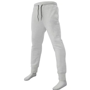 Detail view of men's white waffle knit casual pants, showing texture, drawstring and cuffed hem.