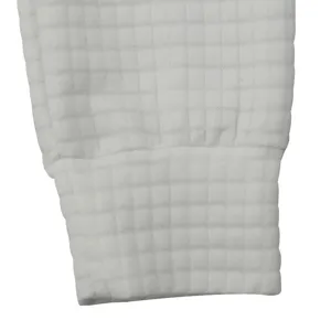 Close-up of white waffle knit casual pants cuff, showing soft textured fabric and elastic hem.