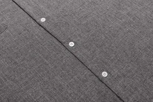 Detail shot of grey linen shirt fabric and white buttons, casual men's summer top close-up.