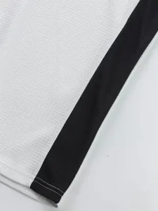 Close-up detail of men's waffle knit long sleeve top fabric with black contrast side stripe.