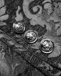 Gothic steampunk jacket metal button detail macro shot, vintage black brocade fabric texture.