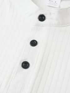 Close-up detail of mens white ribbed knit sleeveless top featuring black buttons and collar.
