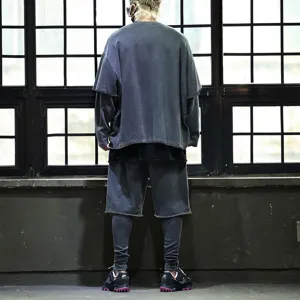Detail view of men's oversized washed dark grey layered t-shirt and shorts set in urban setting.