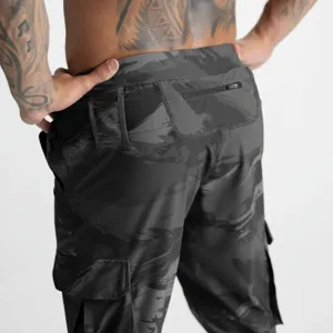 Vue détaillée de pantalon cargo camouflage sombre, pantalon tactique homme avec poche zippée.