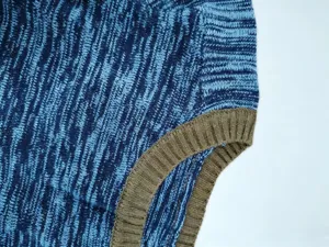 Close-up detail of men's blue knit sweater with ribbed trim, soft and stretchy fabric.