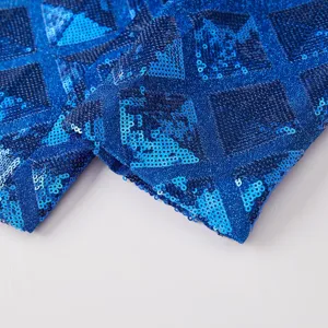 Blue sequin fabric detail close-up showing geometric pattern texture for apparel tailoring.