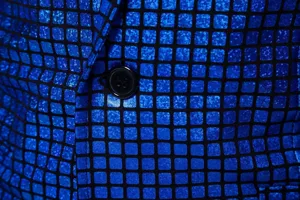 Détail blazer homme à carreaux sequins bleus, tissu élégant de veste de costume de fête de club.
