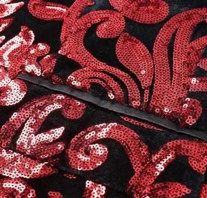 Close-up detail of men black velvet sequin red floral pattern fabric suit jacket lapel.