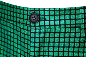 Gros-plan sur la ceinture d'un pantalon de costume disco à sequins pour homme avec bouton noir.