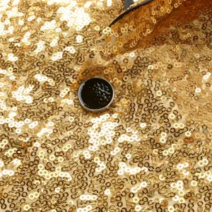 Detalle en primer plano de chaqueta de traje disco con lentejuelas doradas para hombre.