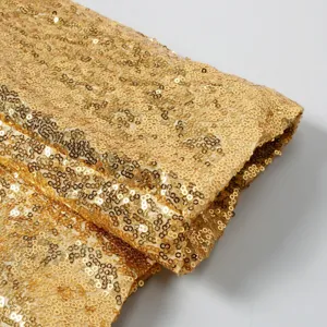 Primer plano detallado de la textura de tela de lentejuelas doradas, material brillante.