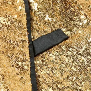 Detalle en primer plano de tela de lentejuelas doradas y solapa de satén negro, chaqueta.