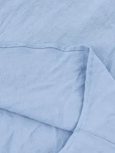 Close-up detail of light blue men's casual linen shirt fabric showing fine texture.