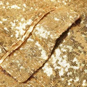 Detalle de blazer de lentejuelas doradas primer plano que muestra textura de tela.
