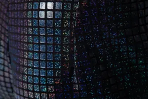 Gros plan détaillé du tissu texturé carré holographique pour le costume de scène.