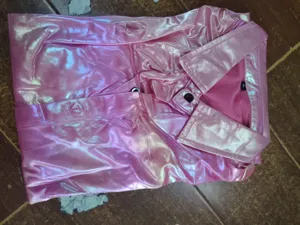 Vue détaillée de la chemise disco rose brillante à manches longues, pliée proprement avec col.