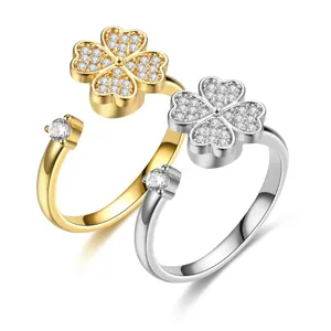 Detailed macro shot of rotating four-leaf clover open rings in gold and silver finishes