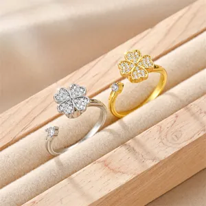 Detailed view of gold and silver rotatable four-leaf clover open rings with crystals