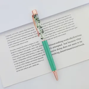 Macro view of a dried flower oil-infused ballpoint pen with rose gold accents