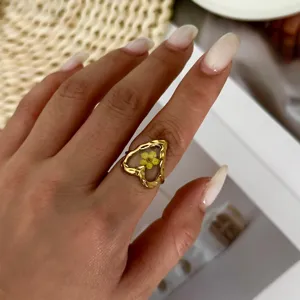 Detailed close-up of a vintage gold heart ring featuring a real yellow dried flower