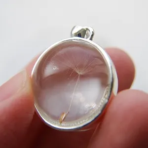 Close-up detail of real dandelion seed inside a glass ball pendant necklace