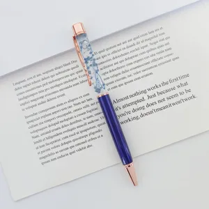 Elegant ballpoint pen with blue dried flowers in floating oil, rose gold accents