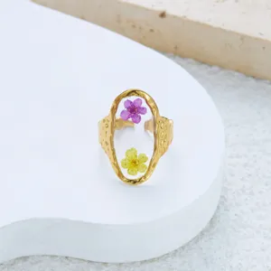 Close-up of vintage textured gold ring featuring real purple and yellow dried flowers