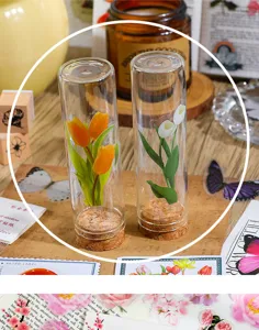 Klares Glasfläschchen mit bunten Tulpenblüten im Inneren, ideal für Tagebuchdeko und Basteln.
