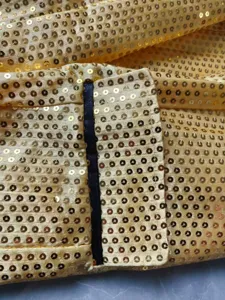 Vue rapprochée de détail de blazer à sequins dorés, texture élégante de tissu de costume brillant