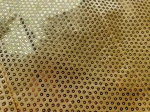 Gros plan de la texture du tissu à paillettes dorées brillantes pour vestes élégantes.