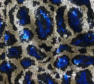 Close-up detail of blue and gold sequin leopard print fabric for stage costume apparel.