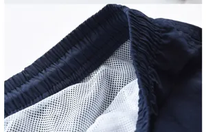 Dettaglio pantaloncini mare uomo, cintura elastica, fodera in rete bianca traspirante.