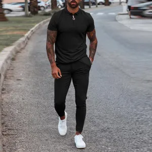 Outdoor street detail shot of men's black short sleeve zipper polo and casual trousers set.