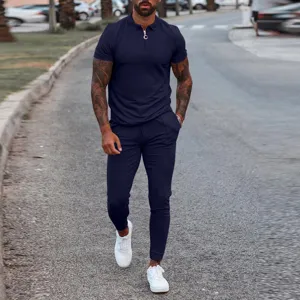 Men's two piece summer outfit featuring a short sleeve polo shirt and matching casual trousers set.