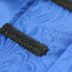 Close-up view of blue vintage coat fabric and intricate black braided trim detail.